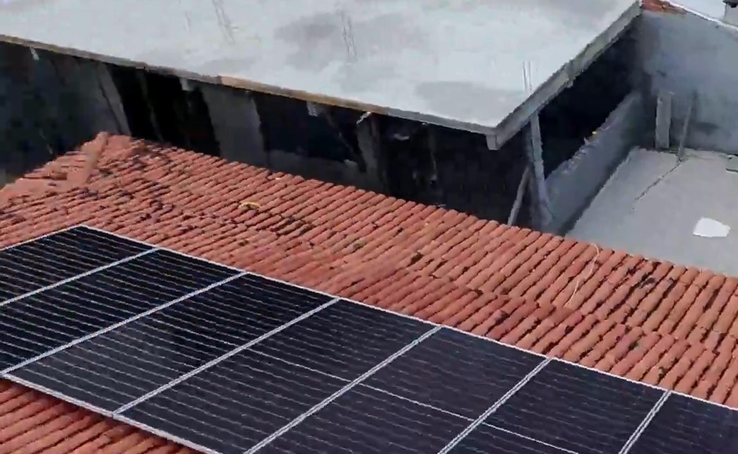 Módulos solares instalados pela DGE em telhado cerâmico em Barra de Jacuípe, ao lado da piscina